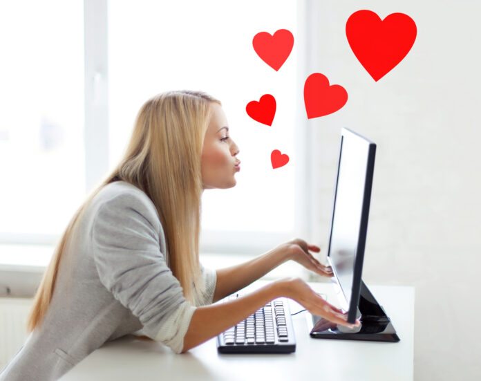 woman sending kisses with computer monitor